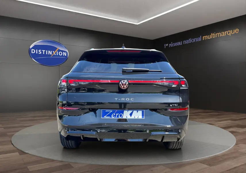 Vue arrière du Volkswagen T-Roc noir ébène 2026, version eTSI 150 DSG7 R-Line avec attelage et feux LED distinctifs.