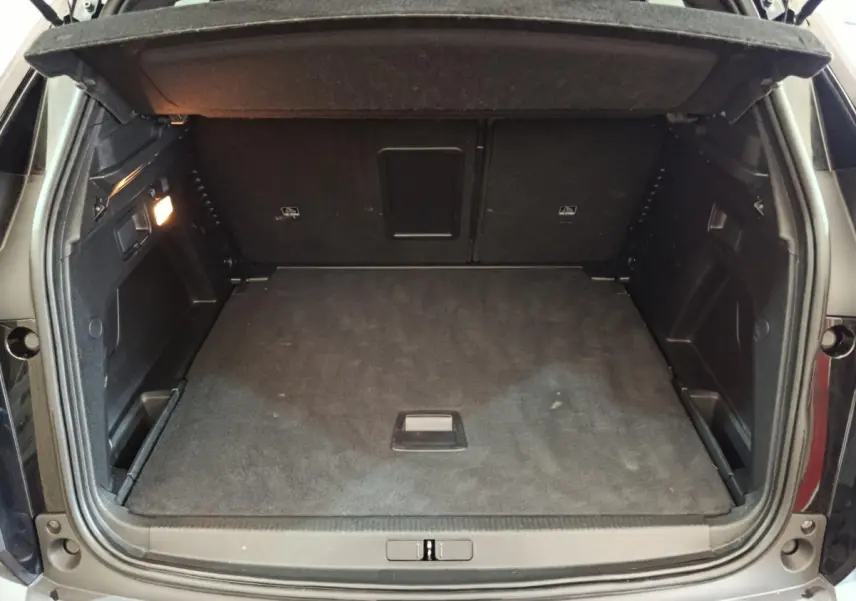 Coffre ouvert vu de l'arrière d'un Peugeot 3008 noir, montrant un espace de chargement propre et spacieux.