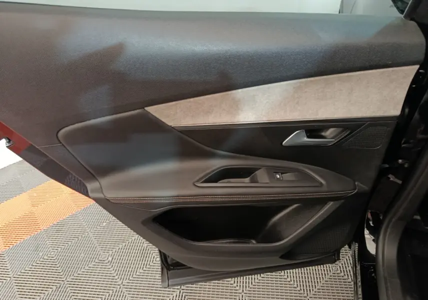 Vue intérieure de la porte arrière gauche noire du Peugeot 3008 2022, avec garniture tissu et plastique.