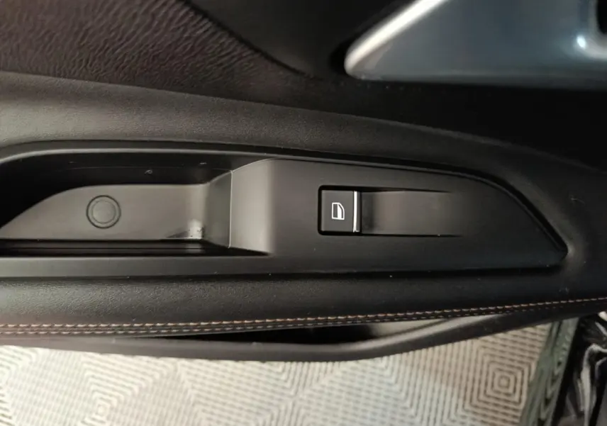 Détail de la commande de condamnation centralisée sur la porte intérieure côté gauche du Peugeot 3008 noir 2022.