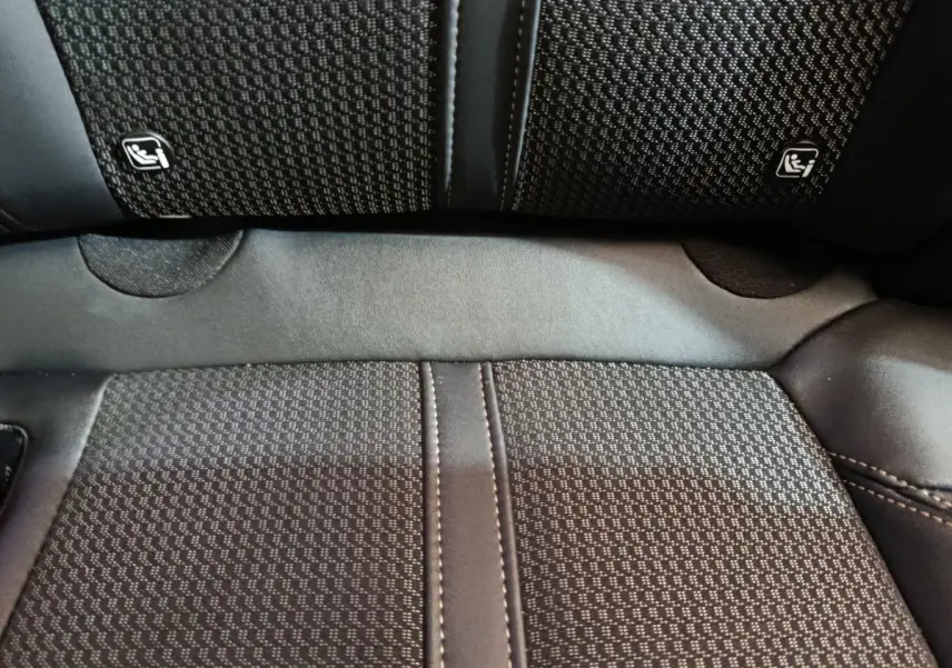 Gros plan sur la banquette arrière noire du Peugeot 3008 avec logos Isofix visibles sur les dossiers des sièges.