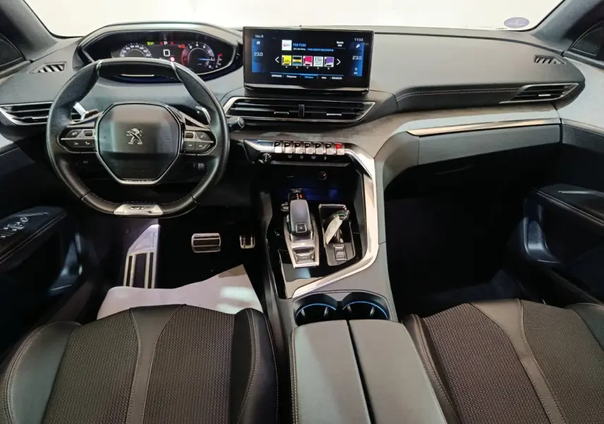 Vue intérieure avant du Peugeot 3008 noir 2022, tableau de bord numérique et écran tactile central lumineux.