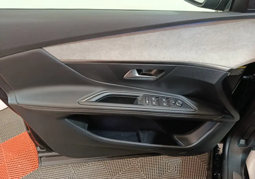 Vue intérieure côté gauche de la porte avant noire du Peugeot 3008 avec commandes des vitres et poignée intégrée.