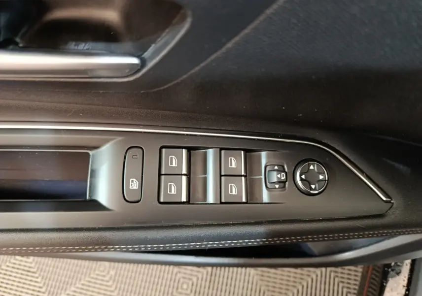 Gros plan sur les commandes des lève-vitres et rétroviseurs côté gauche noir du Peugeot 3008 PureTech 130 GT 2022.