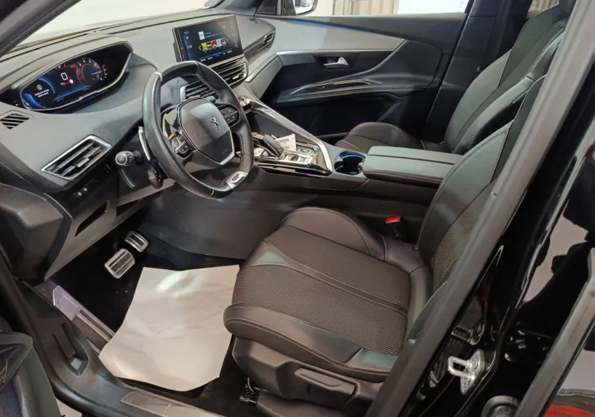 Intérieur noir du Peugeot 3008 GT 2022 vu côté conducteur, avec tableau de bord digital et volant cuir compact.