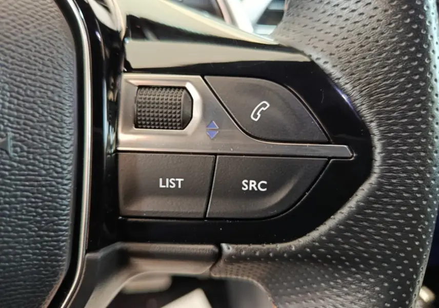 Gros plan sur les commandes gauche du volant en cuir perforé du Peugeot 3008 noir PureTech 130 GT 2022.