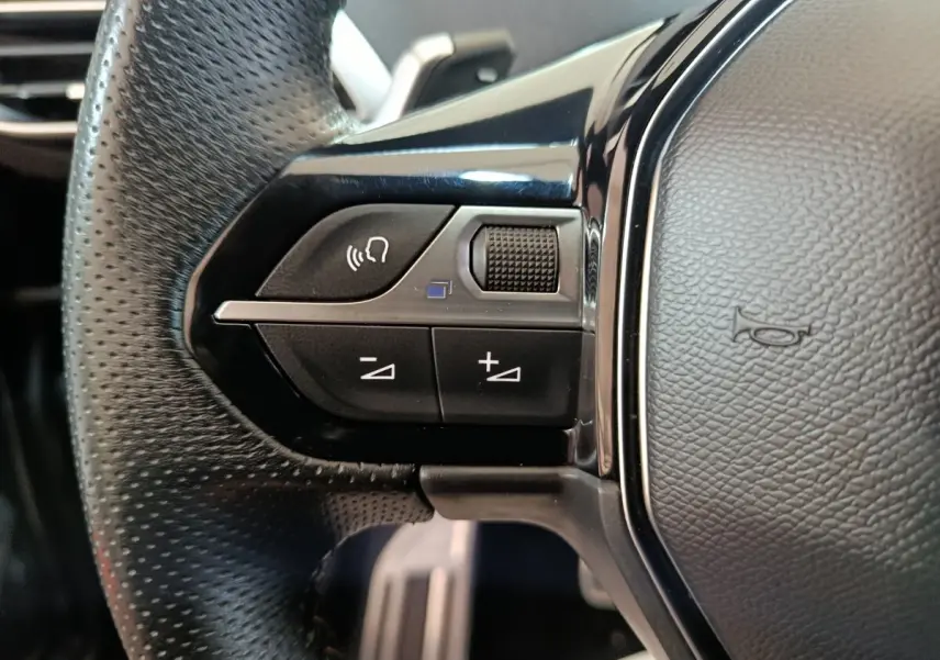 Gros plan sur les commandes gauche du volant cuir noir du Peugeot 3008 PureTech 130 GT 2022.