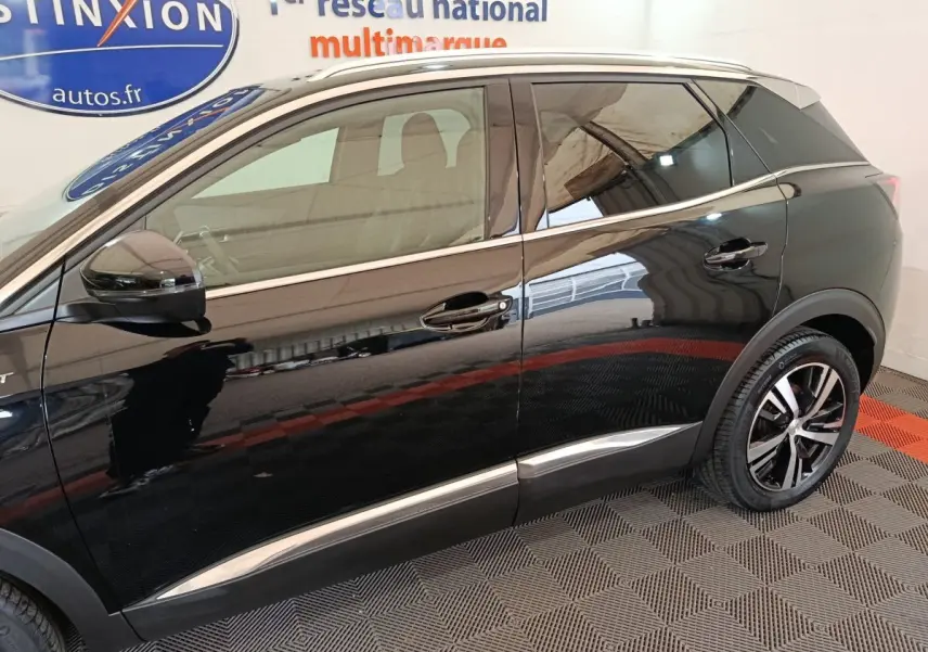 Vue latérale gauche d’un Peugeot 3008 noir 2022 avec jantes alliage et barres de toit chromées visibles.