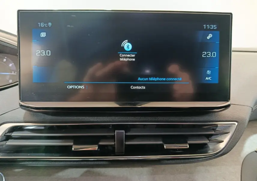 Écran tactile central du tableau de bord du Peugeot 3008 noir, affichant la connexion Bluetooth et la climatisation à 23°C.