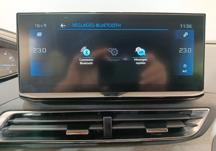 Écran tactile central du tableau de bord du Peugeot 3008 noir, affichant les réglages Bluetooth et température à 23°C.