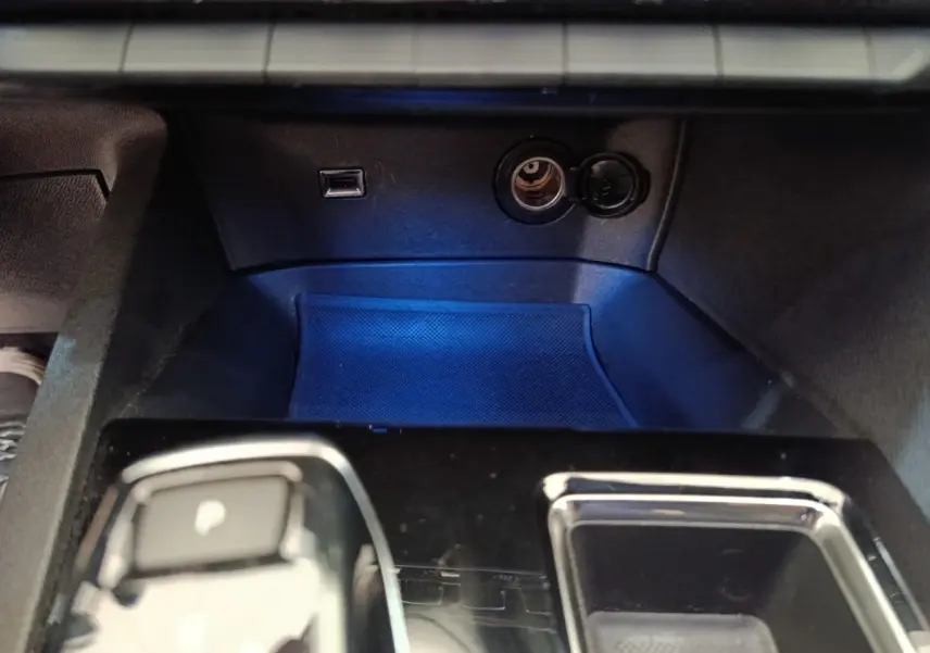 Gros plan sur la console centrale noire du Peugeot 3008 GT 2022, avec prise USB et allume-cigare visibles.