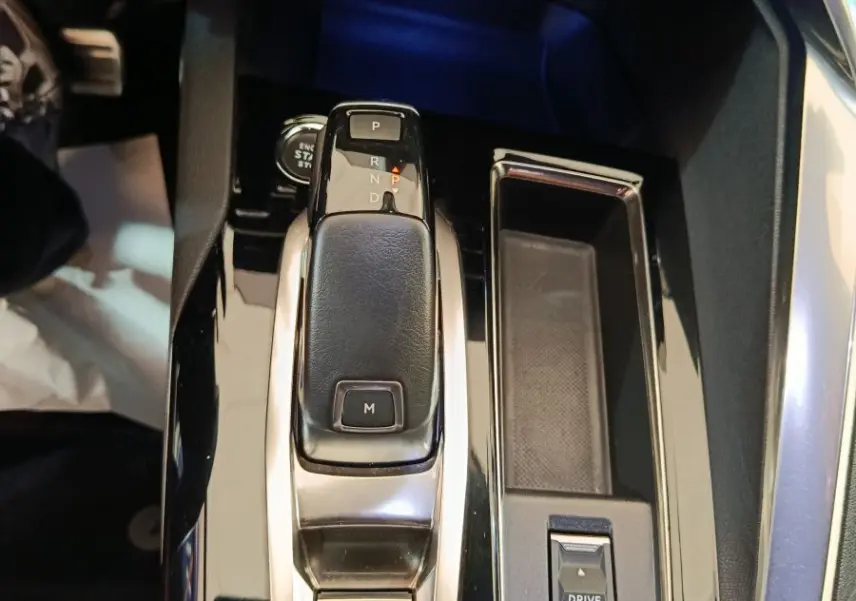Vue rapprochée de la console centrale noire du Peugeot 3008 GT 2022 avec levier de vitesses automatique et commandes Drive Mode.