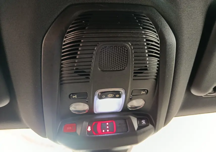 Vue en contre-plongée du plafonnier noir du Peugeot 3008 GT 2022 avec éclairage et boutons de commande rouges.