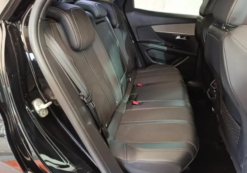 Vue côté gauche des sièges arrière en cuir noir du Peugeot 3008 PureTech 130 GT 2022 avec portières ouvertes.