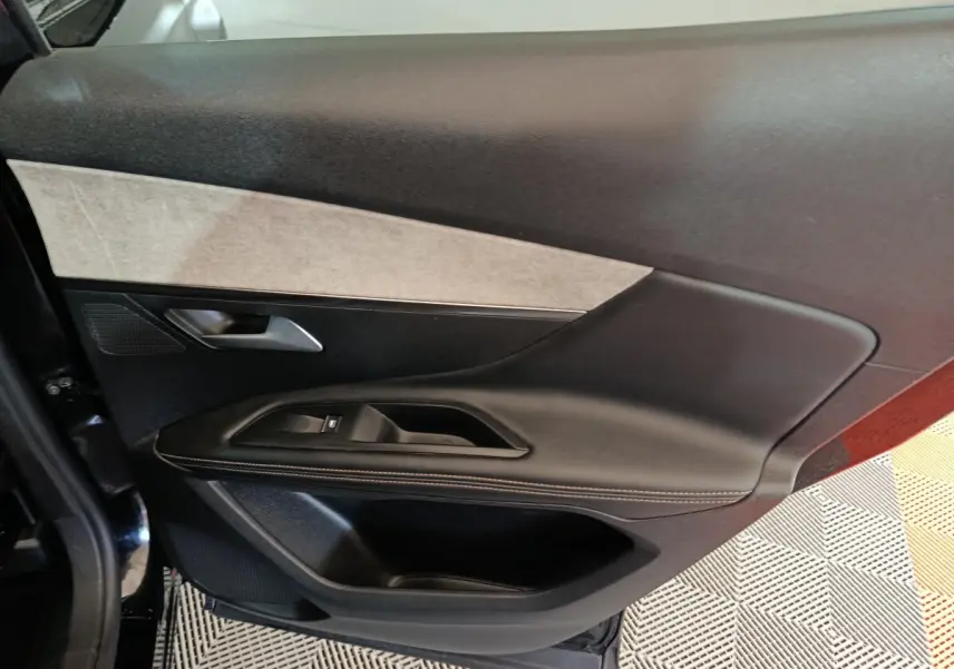 Vue intérieure de la porte côté gauche du Peugeot 3008 noir, avec garniture noire et insert gris clair.