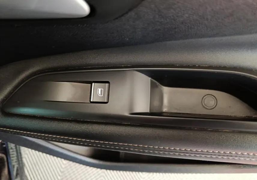 Gros plan sur le bouton de lève-vitre côté gauche noir avec surpiqûres marron du PEUGEOT 3008 PureTech 130 GT 2022.