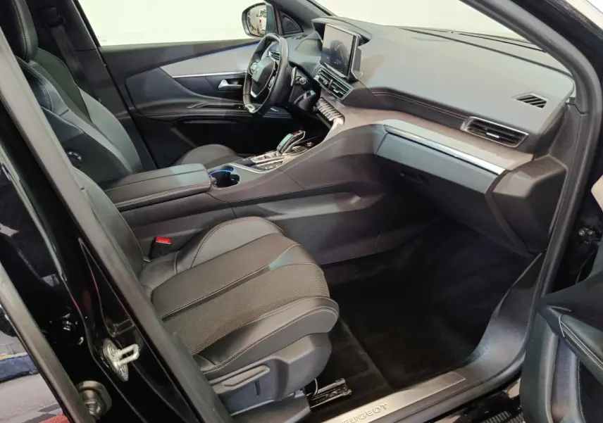 Vue intérieure côté passager du Peugeot 3008 noir 2022, mettant en valeur les sièges en cuir et le tableau de bord moderne.