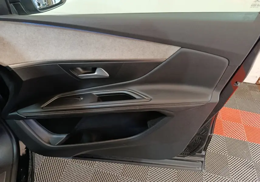 Vue intérieure de la porte côté gauche d’un Peugeot 3008 noir, avec garniture noire et insert beige clair.