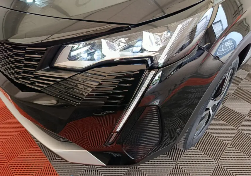 Gros plan sur l'avant droit noir brillant du Peugeot 3008 2022 avec phares LED et calandre distinctive.