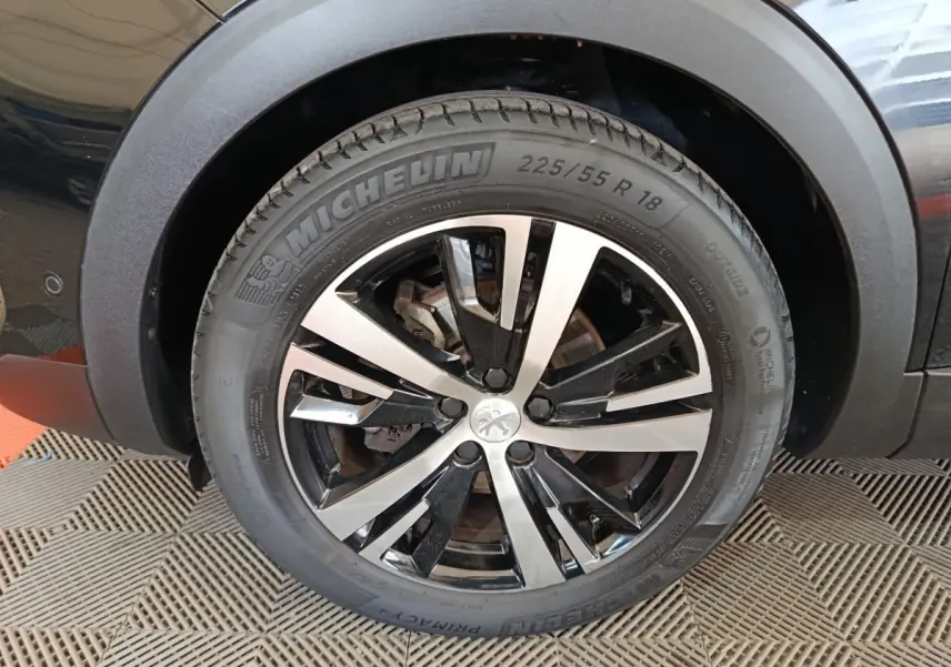 Gros plan sur la roue avant droite noire avec jante alliage bicolore du Peugeot 3008 PureTech 130 GT 2022.