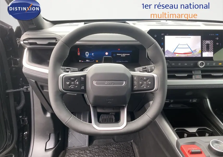 Vue intérieure centrée sur le volant Jeep Compass 2026, tableau de bord numérique et écran multimédia avec caméra de recul.