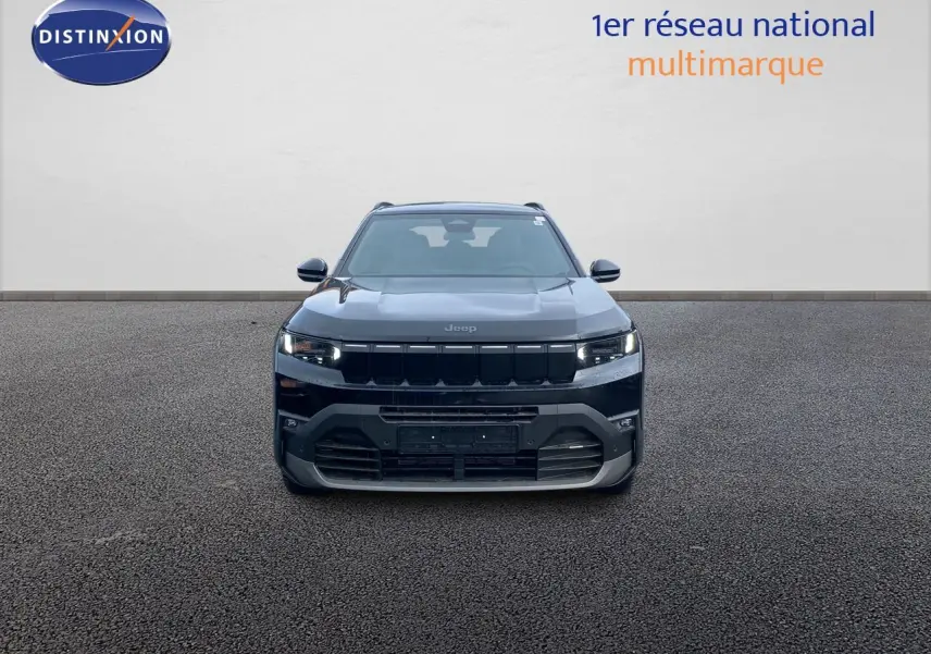 Vue frontale d'un Jeep Compass noir Vulcano métallisé, mettant en valeur sa calandre et ses phares LED allumés.
