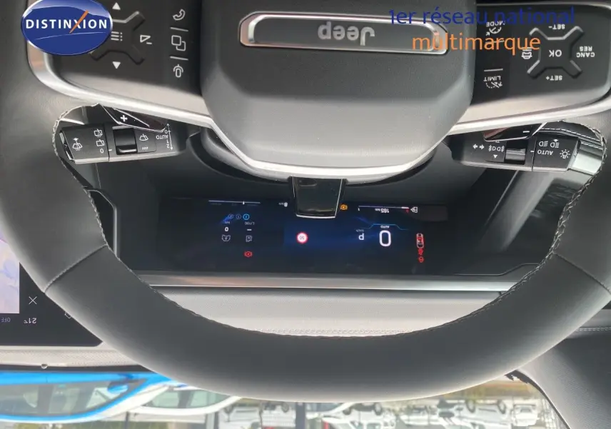 Vue rapprochée du volant noir cuir du Jeep Compass 2026 avec commandes intégrées et tableau de bord numérique visible.