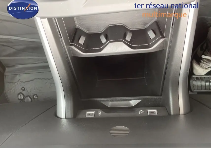 Vue rapprochée de la console centrale du Jeep Compass noir Vulcano, montrant les ports USB et un rangement intégré.