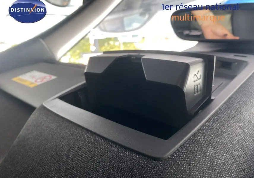 Détail intérieur du tableau de bord du Jeep Compass 2026 noir Vulcano, mettant en valeur un compartiment de rangement ouvert.