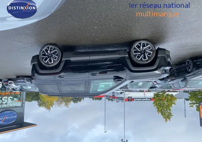 Jeep Compass noir Vulcano métal vu de profil côté gauche sur un parking avec plusieurs autres véhicules autour.