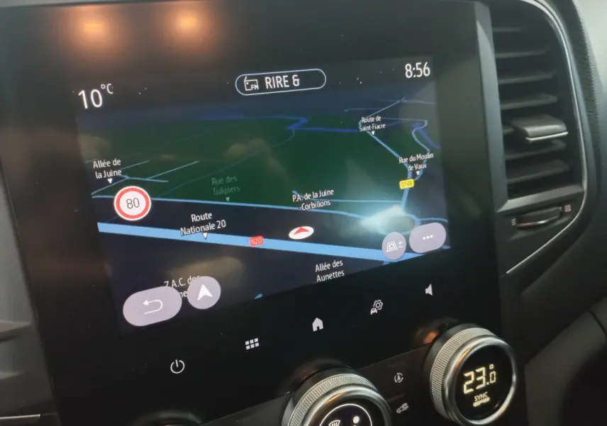 Écran tactile central de navigation et commandes climatisation dans l'habitacle d'une Renault Mégane blanche 2022.