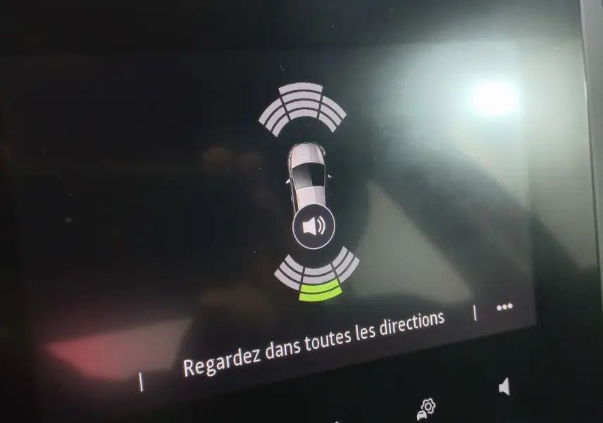 Affichage tactile de la Renault Mégane Business blanc, montrant l'alerte de capteurs de proximité arrière.