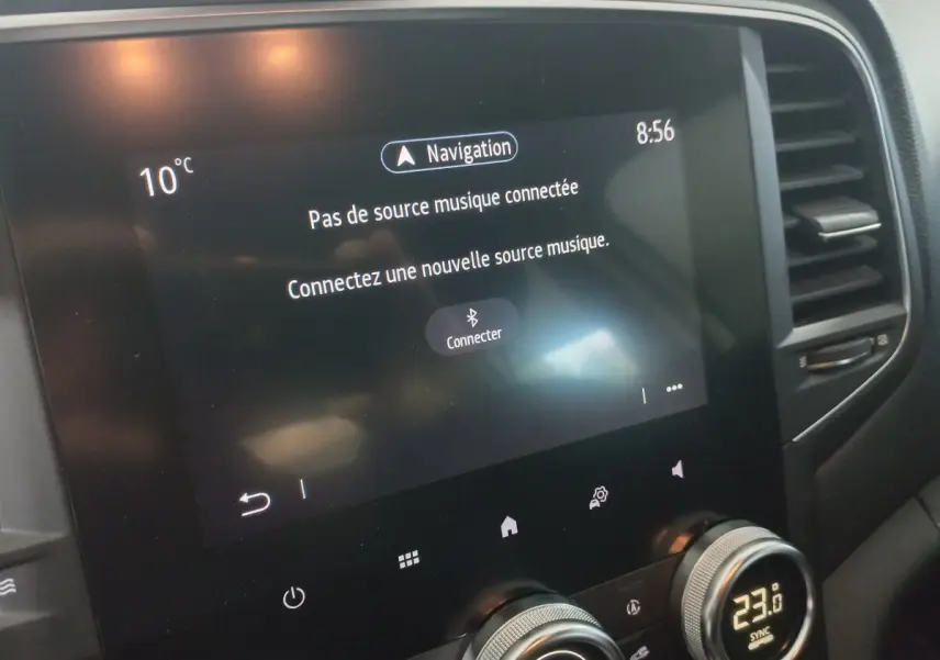 Écran tactile central de la Renault Mégane Business blanc, affichant le menu musique et la température intérieure.