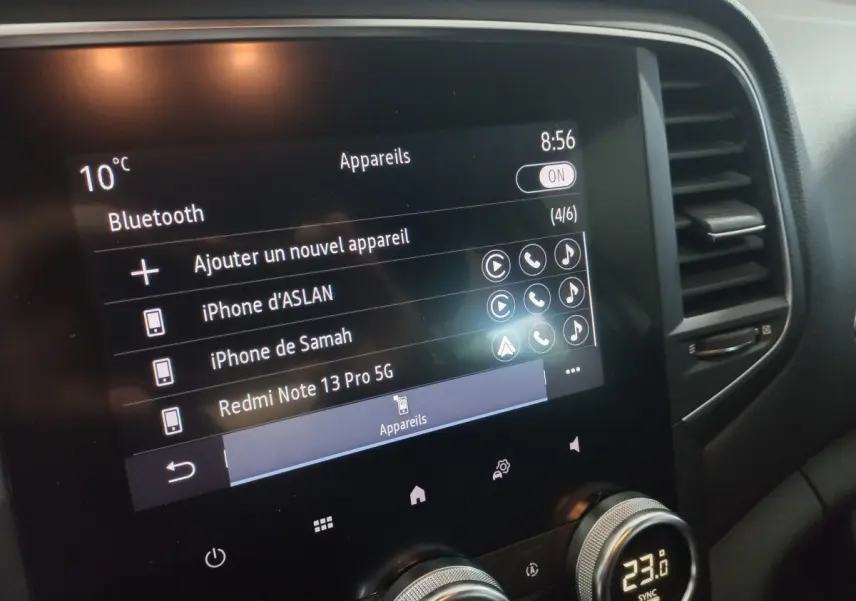Écran tactile central de la Renault Mégane Business blanc, affichant les connexions Bluetooth et la température intérieure.