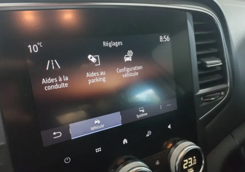 Écran tactile central affichant les réglages d’aide à la conduite et parking dans une Renault Mégane blanche 2022.