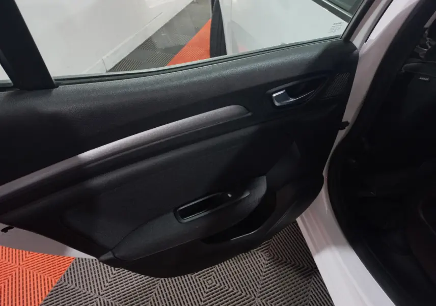 Intérieur côté gauche de la porte arrière d'une Renault Mégane Business Blue dCi blanche, avec poignée et commande de vitre.