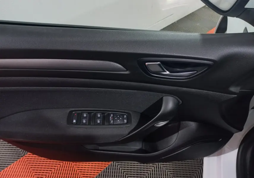 Vue rapprochée de la porte côté gauche d'une Renault Mégane Business blanche, avec commandes électriques des vitres.