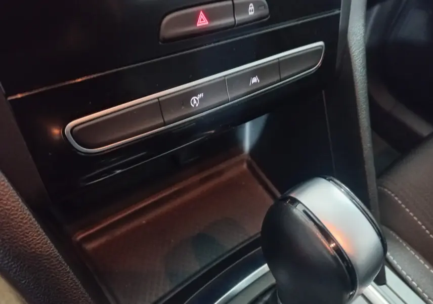 Gros plan sur le levier de vitesse automatique et les commandes centrales noires du tableau de bord de la Renault Mégane Business.
