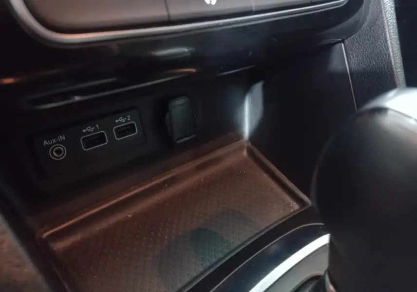 Vue rapprochée de la console centrale noire de la Renault Mégane Business avec ports USB et prise Aux-In visibles