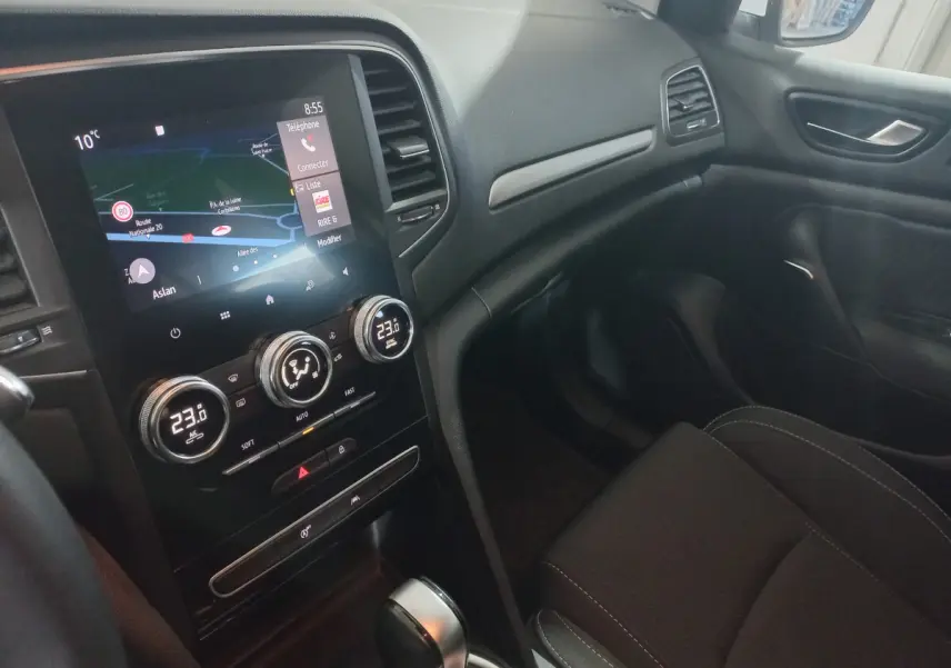 Intérieur avant droit de la Renault Mégane Business blanc, avec écran tactile et commandes climatisation digitales.