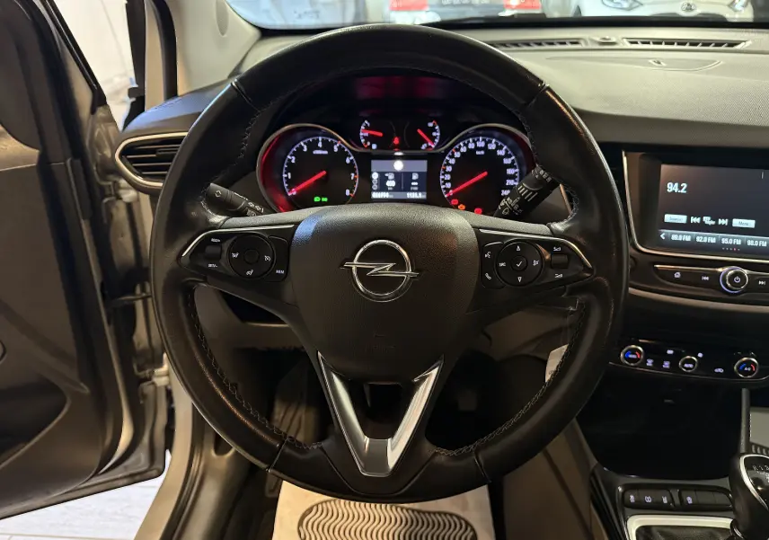 Vue intérieure centrée sur le volant noir de l'Opel Crossland 2023, avec tableau de bord et écran multimédia visibles.