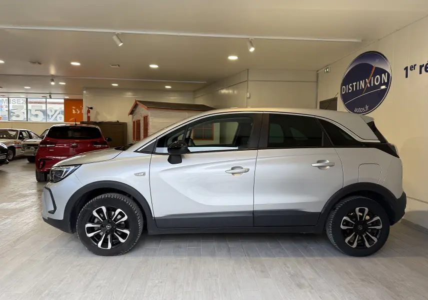 Vue de profil côté gauche de l'Opel Crossland gris 2023 avec jantes alliage et détails noirs contrastants.