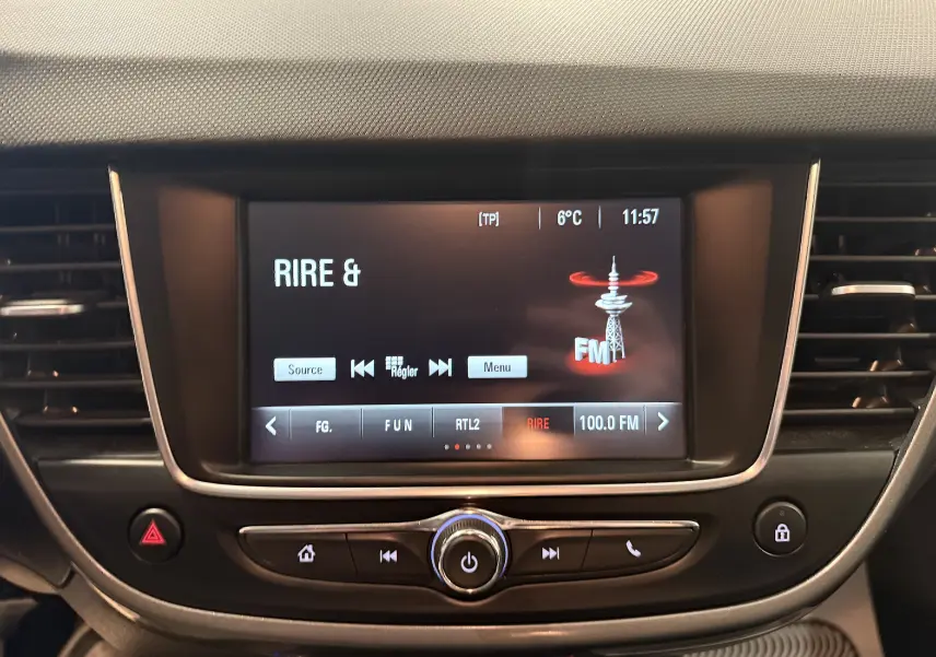 Écran central tactile de l’Opel Crossland 2023 affichant une radio FM sur fond noir avec commandes intégrées.