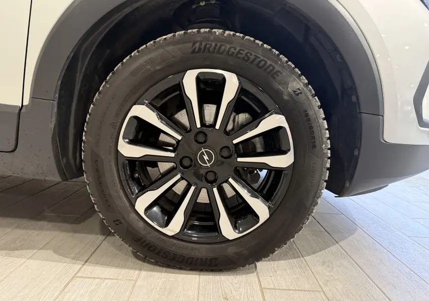 Gros plan sur la roue avant droite d’un Opel Crossland gris 2023, jante noire et argent avec pneu Bridgestone.