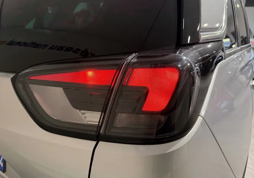 Gros plan sur le feu arrière droit rouge et blanc d’un Opel Crossland gris 2023, soulignant les lignes modernes du véhicule.