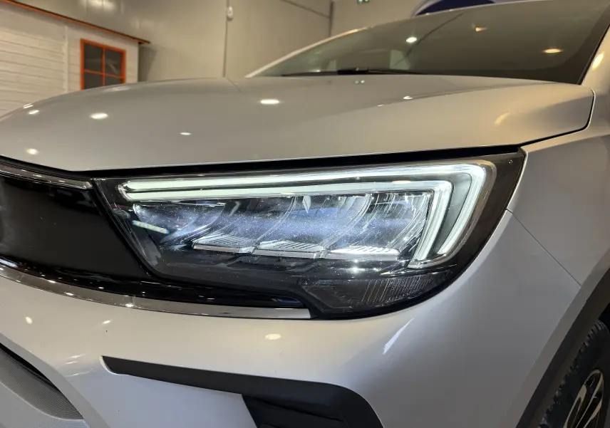 Gros plan sur le phare avant droit du SUV Opel Crossland gris 2023, soulignant son design LED moderne.