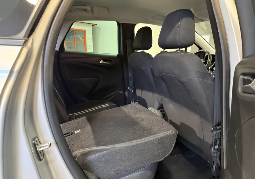 Vue intérieure côté gauche arrière de l’Opel Crossland gris 2023, siège arrière rabattable pour agrandir le coffre.