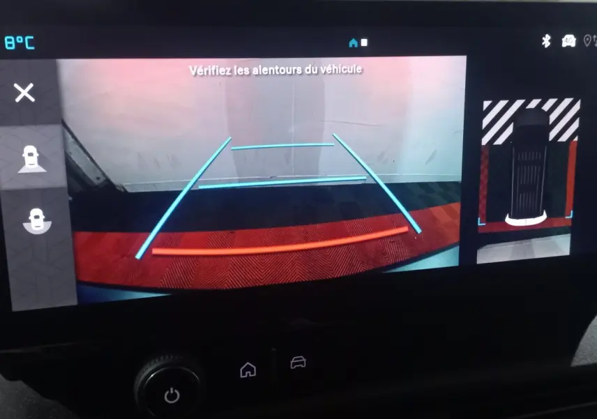 Vue de l'écran de caméra de recul du Citroën Berlingo blanc, avec lignes de guidage et affichage de l'environnement arrière.