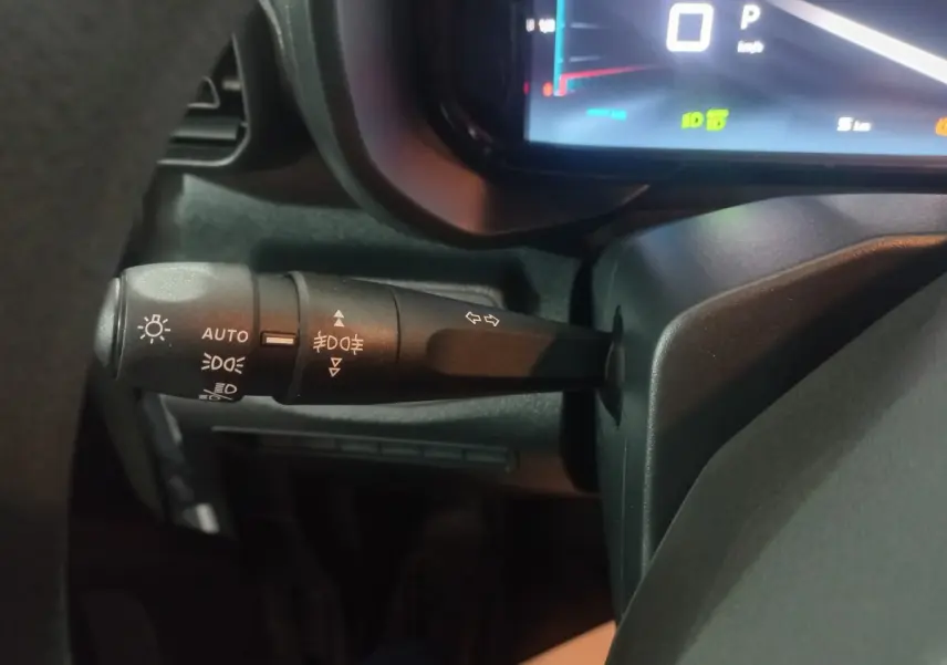 Gros plan sur la manette de commande des feux à gauche du volant dans l’habitacle du Citroën Berlingo blanc 2025.