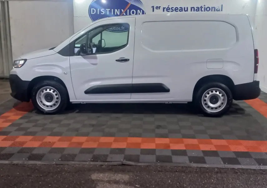 Vue de profil côté gauche d'un utilitaire Citroën Berlingo XL blanc, avec protections latérales noires et jantes acier simples.